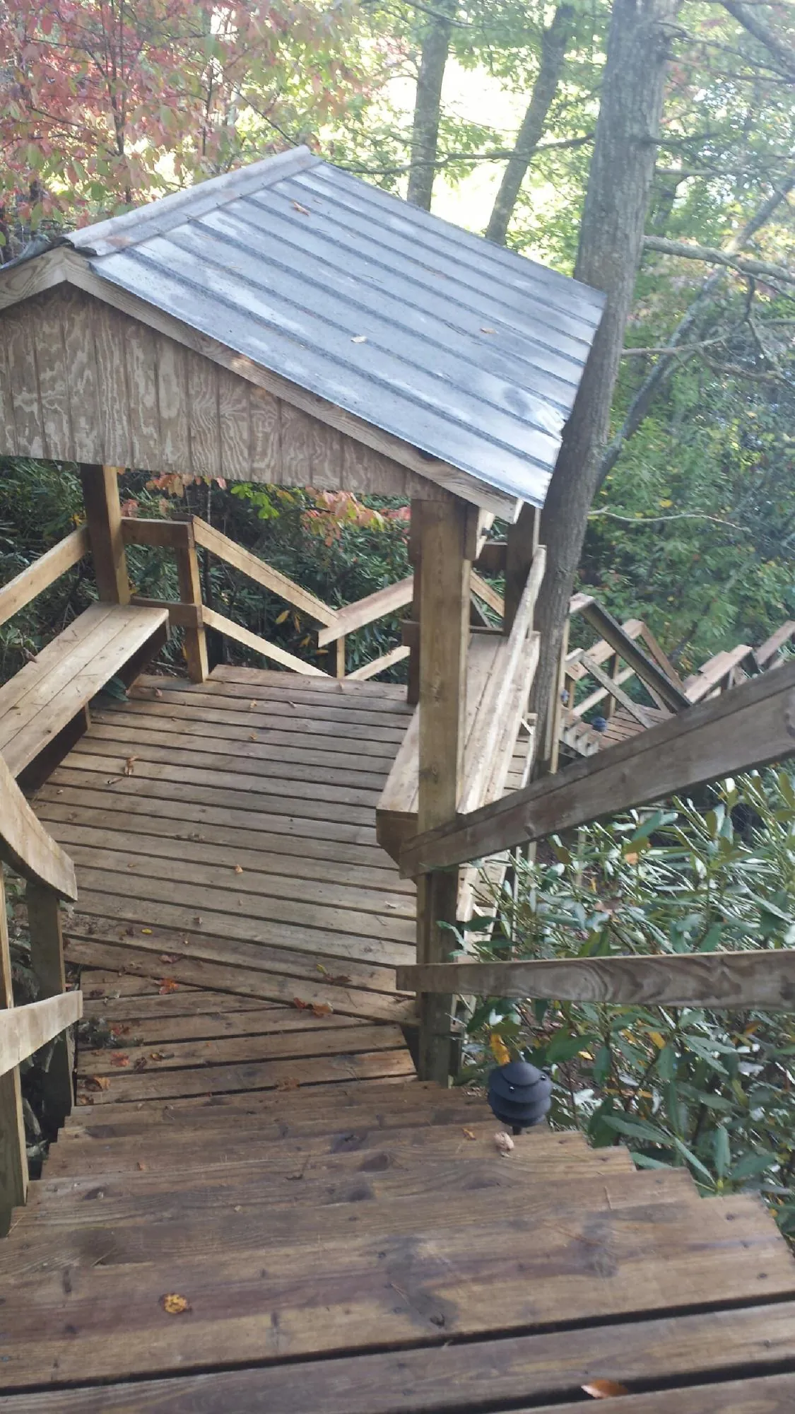 Metal roofed shelter over wooden steps on a wooded walkway — Skylight Repair & Installation work by our crew in El Granada